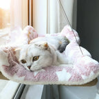 Cat sleeping on window lounger perch with city view